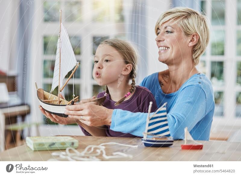 Happy mother and daughter playing with model boat at home mommy mothers ma mummy mama Toy Boat happiness happy daughters parents family families people persons
