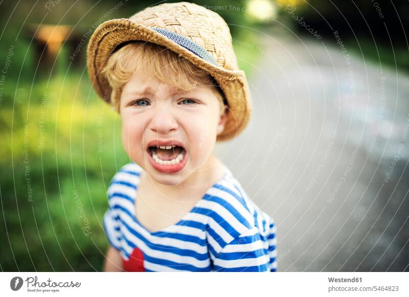 Portrait of screaming toddler wearing straw hat boy boys males shouting straw hats portrait portraits child children kid kids people persons human being humans