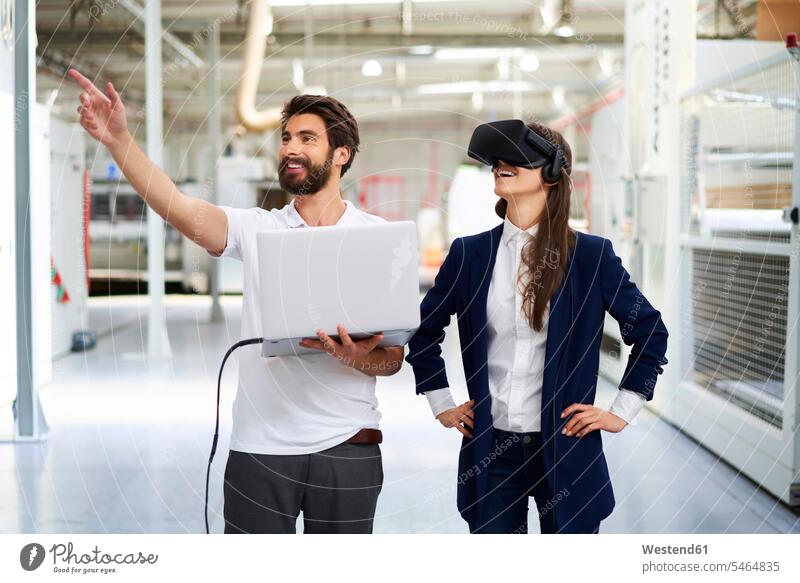 Man with laptop and businesswoman wearing VR glasses in factory colleague Occupation Work job jobs profession professional occupation business life