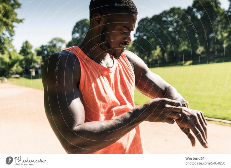 Young athlete in training on sports field taking the time on his smartwatch Time Sportspeople Sportsman Sportsperson athletes Sportsmen Sport Training fit