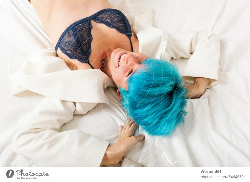 Grunge lesbian woman lying on bed turquoise Turquoise Color laying down lie lying down laughing Laughter females women smiling smile homosexual woman lesbians