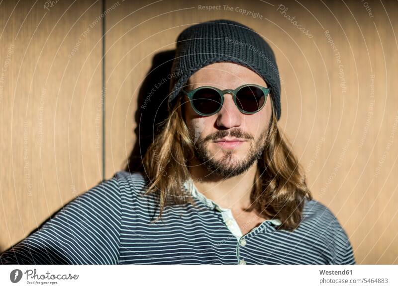 Portrait of bearded man with long hair wearing sunglasses and wooly hat sun glasses Pair Of Sunglasses men males woolly hat Wooly Hat Knit-Hat Knit Hats