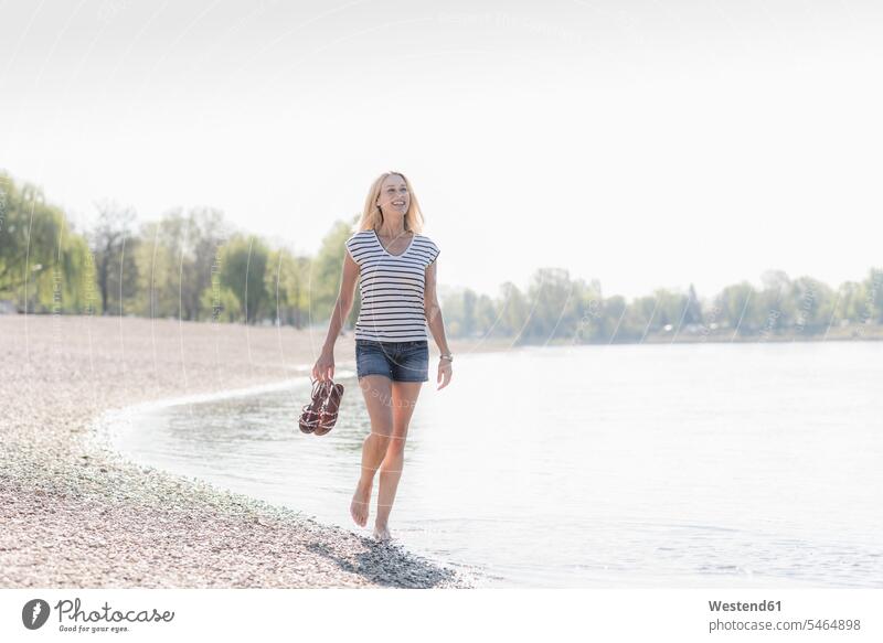 Smiling mature woman wading in a river Germany top tops getting away from it all Getting Away From All unwinding relaxing stripes striped riverside riverbank