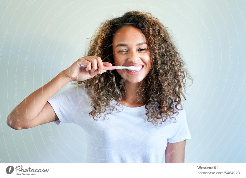Happy young woman enjoying while brushing teeth against wall color image colour image indoors indoor shot indoor shots interior interior view Interiors Spain