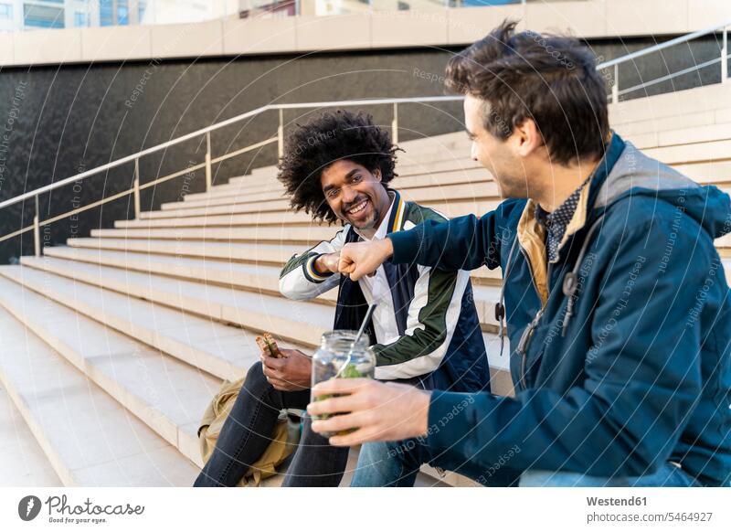 Two happy casual businessmen sitting on stairs having lunch break human human being human beings humans person persons caucasian appearance caucasian ethnicity