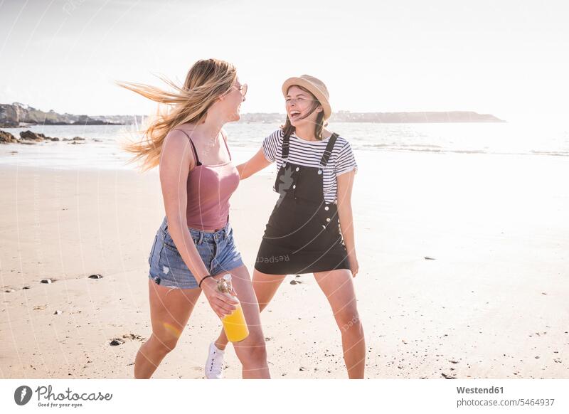 Two girlfriends having fun, running and jumping on the beach human human being human beings humans person persons caucasian appearance caucasian ethnicity