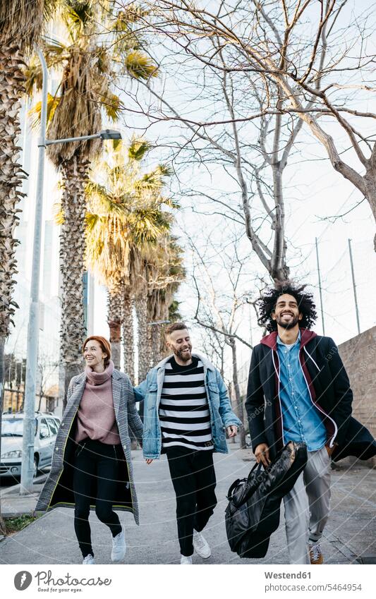 Three happy friends walking in the city happiness going friendship Multiracial Group Multi-Ethnic Group Multi Ethnic Group fashionable togetherness style