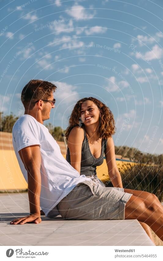 Happy young couple sitting on a pier touristic tourists Eye Glasses Eyeglasses specs spectacles Pair Of Sunglasses sun glasses flirt Flirtation smile Seated