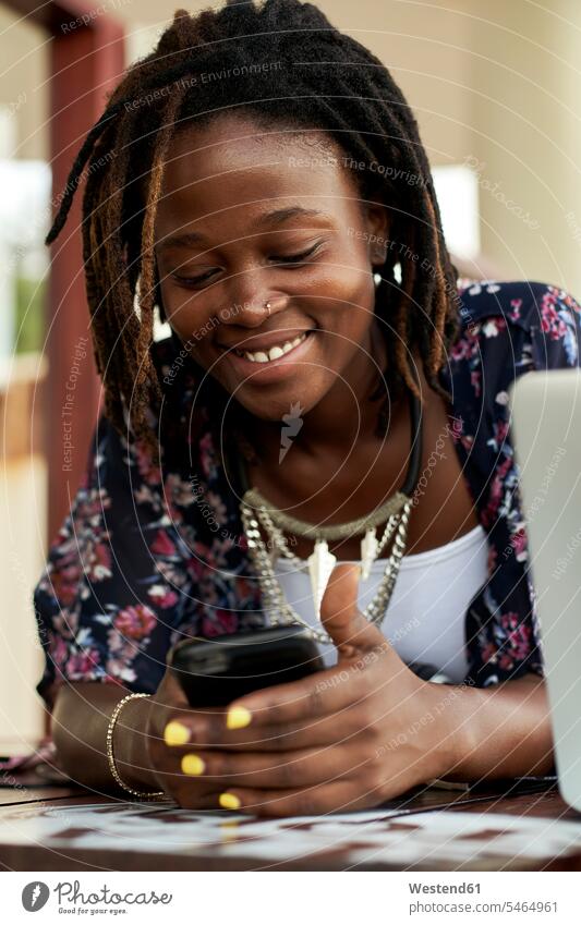 Portrait of happy young woman checking her phone human human being human beings humans person persons African black black ethnicity coloured 1 one person only