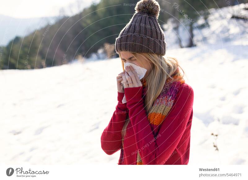 Young blond woman blowing nose in winter human human being human beings humans person persons caucasian appearance caucasian ethnicity european adult grown-up