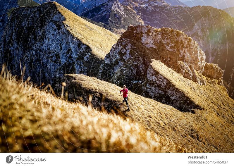 Sportswoman exercising while running on Aggenstein mountain at Bavaria, Germany color image colour image outdoors location shots outdoor shot outdoor shots day