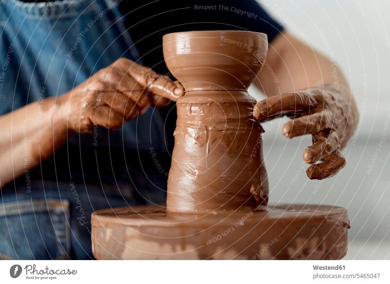 Mature female artist making pottery from clay at workshop color image colour image indoors indoor shot indoor shots interior interior view Interiors Spain
