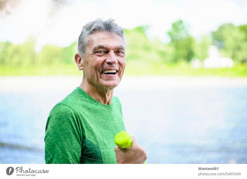Side view portrait of smiling active senior man exercising in park color image colour image outdoors location shots outdoor shot outdoor shots day daylight shot