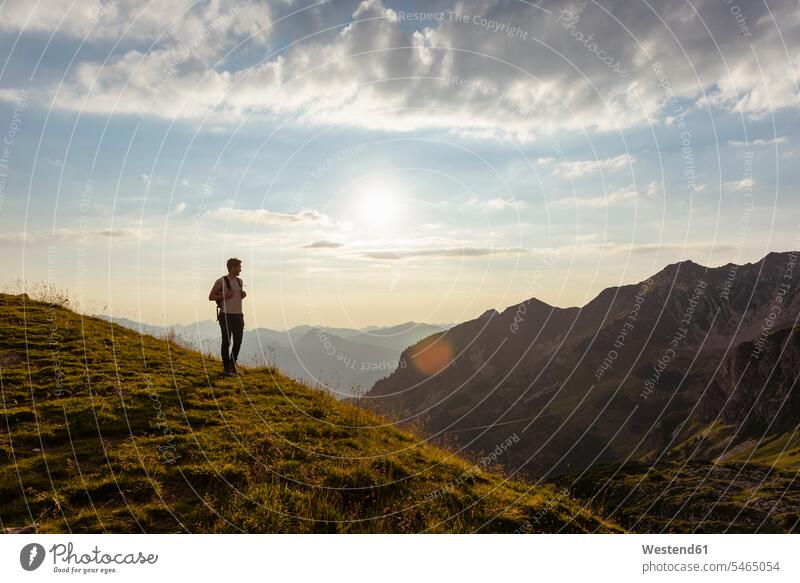 Germany, Bavaria, Oberstdorf, man on a hike in the mountains looking at view at sunset men males sunsets sundown hiking View Vista Look-Out outlook Adults