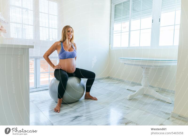 Smiling pregnant woman sitting on fitness ball Fitness Ball Fitness Balls Balance Ball exercise ball Stability Ball Gym Ball Swiss ball Seated Pregnant Woman