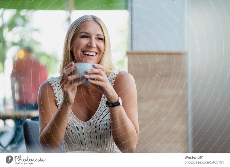 Portrait of happy blond woman drinking coffee in a cafe relax relaxing summer time summertime summery delight enjoyment Pleasant pleasure Cheerfulness