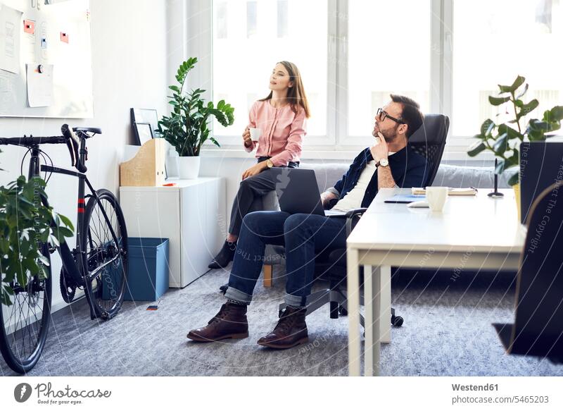 Two colleagues brainstorming in office offices office room office rooms Brainstorming workplace work place place of work graphic designer graphic designers