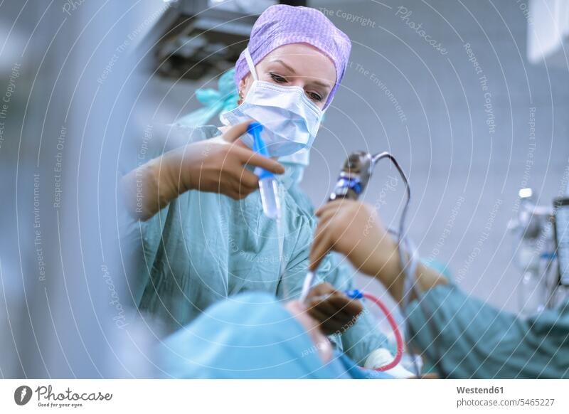 Neurosurgeon in scrubs during an operation hospital Medical Clinic surgery surgeries operating surgical gown Operating Gown Female Doctor physicians