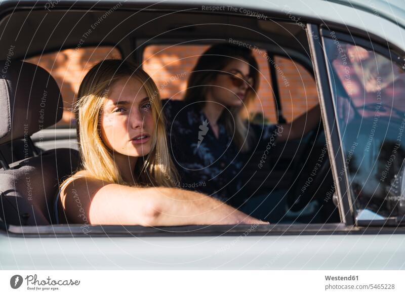 Portrait of young woman sitting in a car with friend female friends portrait portraits Seated automobile Auto cars motorcars Automobiles females women mate