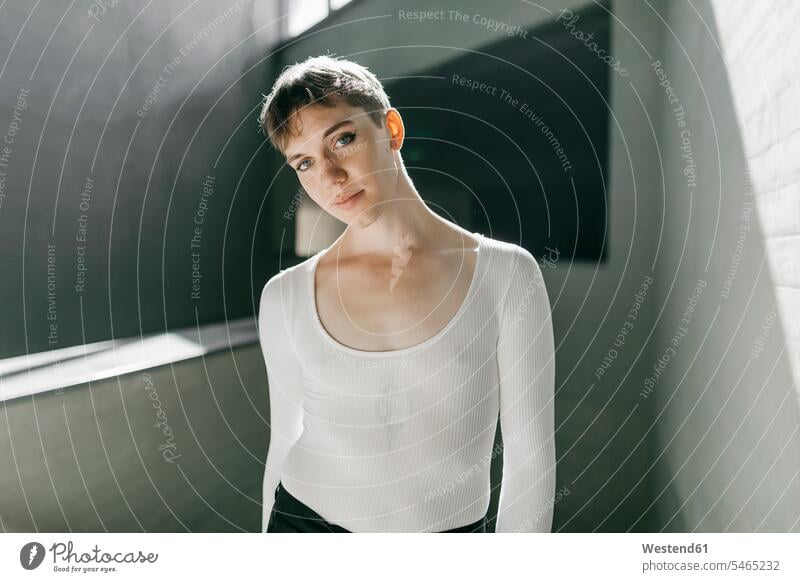 Trans young man wearing white leotard standing in basement color image colour image Spain indoors indoor shot indoor shots interior interior view Interiors