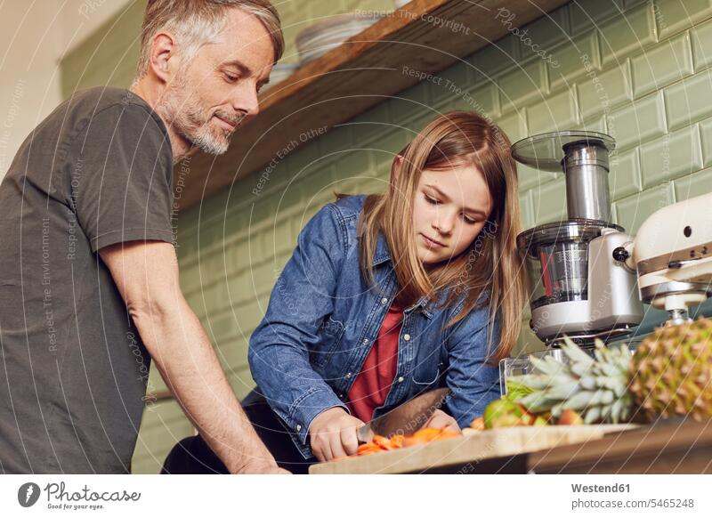 Father and daughter in kitchen preparing fruit and vegetables smile cut delight enjoyment Pleasant pleasure Contented Emotion pleased at home free time