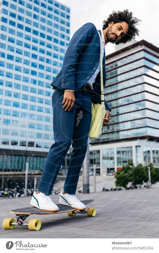 Spain, Barcelona, young businessman riding skateboard in the city Businessman Business man Businessmen Business men Skate Board skateboards town cities towns