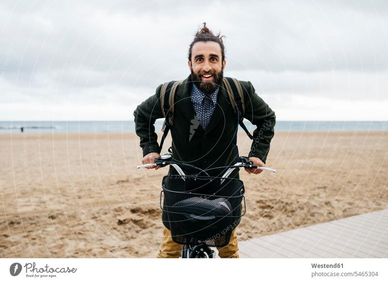 Portrait of happy man with e-bike at the beach E-Bike Electric bicycle Electric Bike beaches portrait portraits men males happiness bikes bicycles Adults