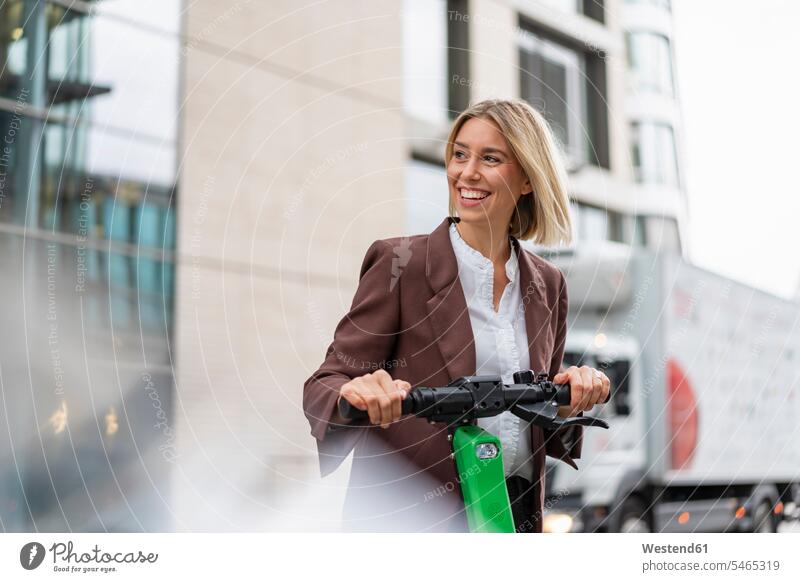 Happy young businesswoman with e-scooter in the city business life business world business person businesspeople business woman business women businesswomen