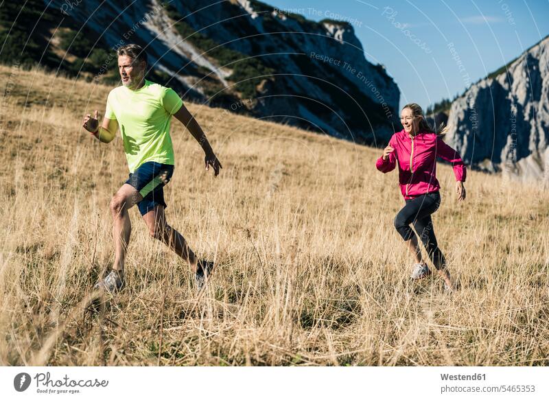 Austria, Tyrol, couple running in the mountains mountain range mountain ranges twosomes partnership couples landscape landscapes scenery terrain people persons