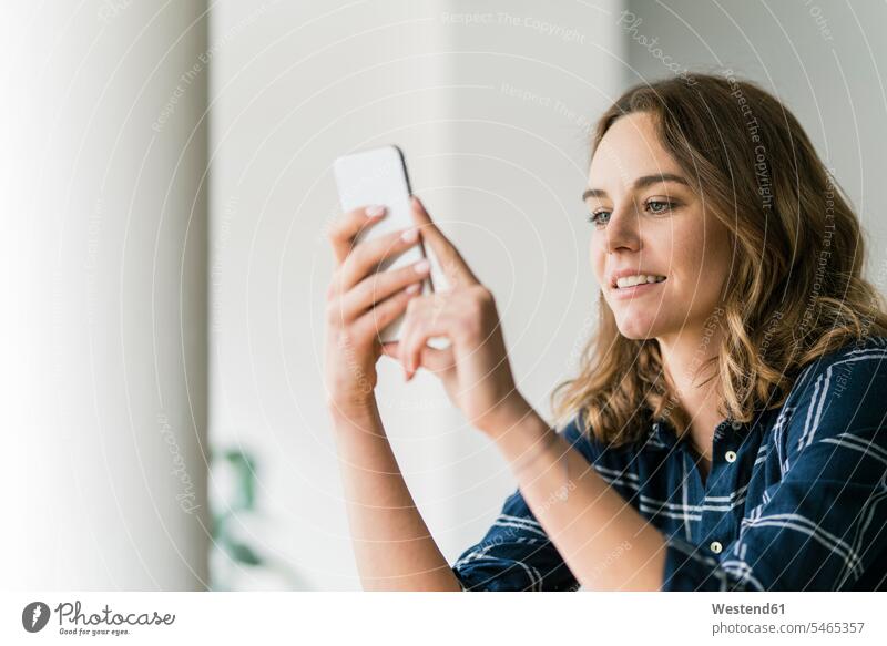 Young woman using smartphone, smiling human human being human beings humans person persons caucasian appearance caucasian ethnicity european 1 one person only