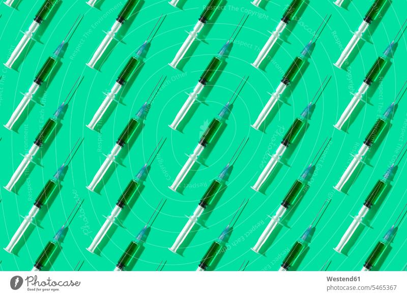 Multiple syringes organized in a pattern over green background blood Conformity alike conform Conformance organisation organised organization pointed pointy