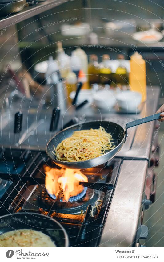 Chef cooking pasta in Italian restaurant kitchen Occupation Work job jobs profession professional occupation Chefs cooks devices Cookers Gas Stove Burner