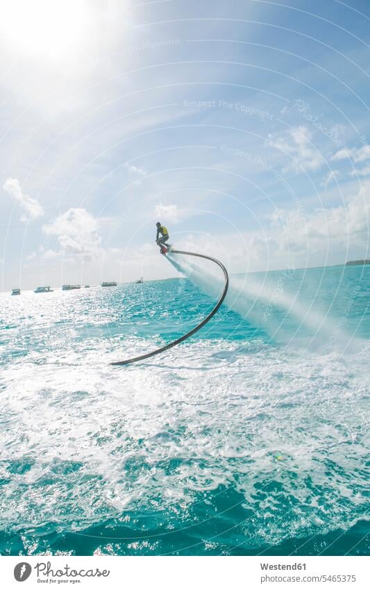 Maldives, man on flyboard above the sea Flyboard ocean men males water waters body of water Adults grown-ups grownups adult people persons human being humans