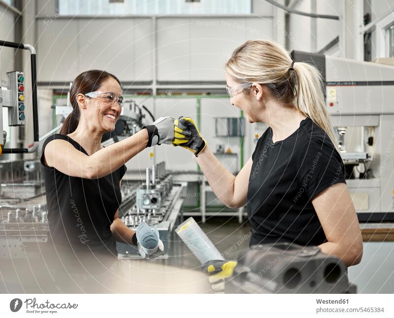 Two woman at work, fist bump Austria protective glove protective gloves male profession worker female workers metalworking metal fabrication metal working