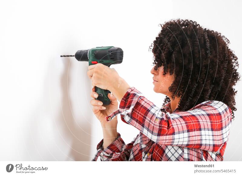 Woman using portable drill, marking with pencil on a wall pencils pens hold stand at home Do it yourself Do-it-yourself Doityourself free time leisure time