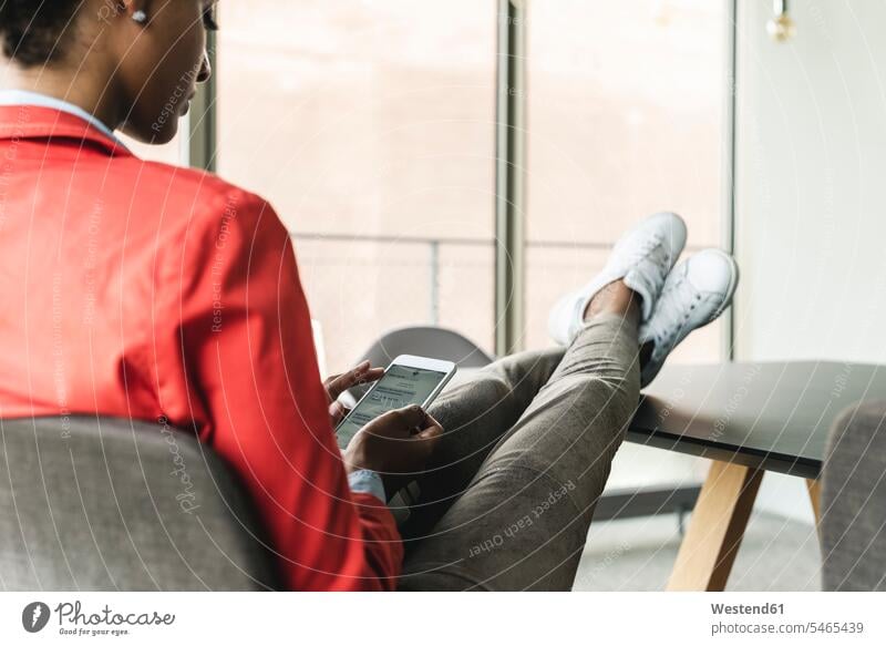 Young businesswoman sitting at desk with feet up, using digital tablet desks Seated relaxed relaxation Table Tables relaxing Mixed Race Person mixed-race Person
