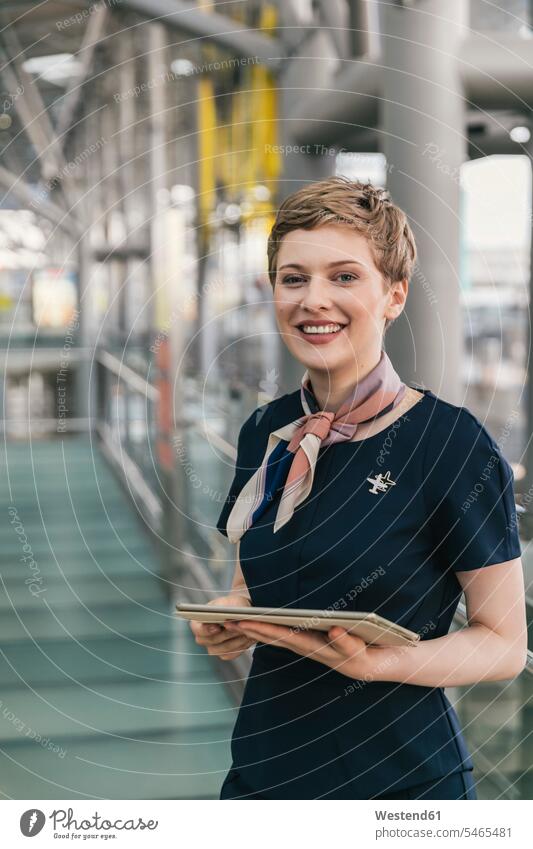 Portrait of smiling airline employee holding tablet at the airport airports stewardess air hostess stewardesses digitizer Tablet Computer Tablet PC