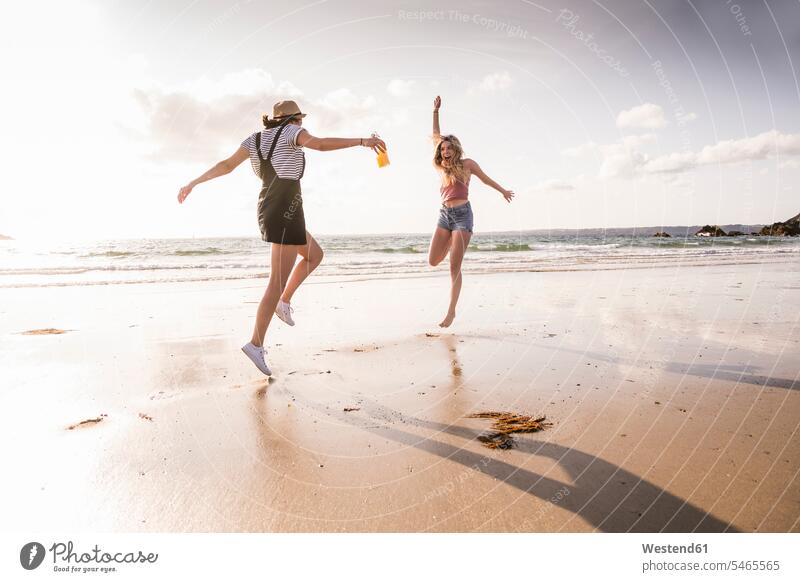 Two girlfriends having fun, running and jumping on the beach human human being human beings humans person persons caucasian appearance caucasian ethnicity