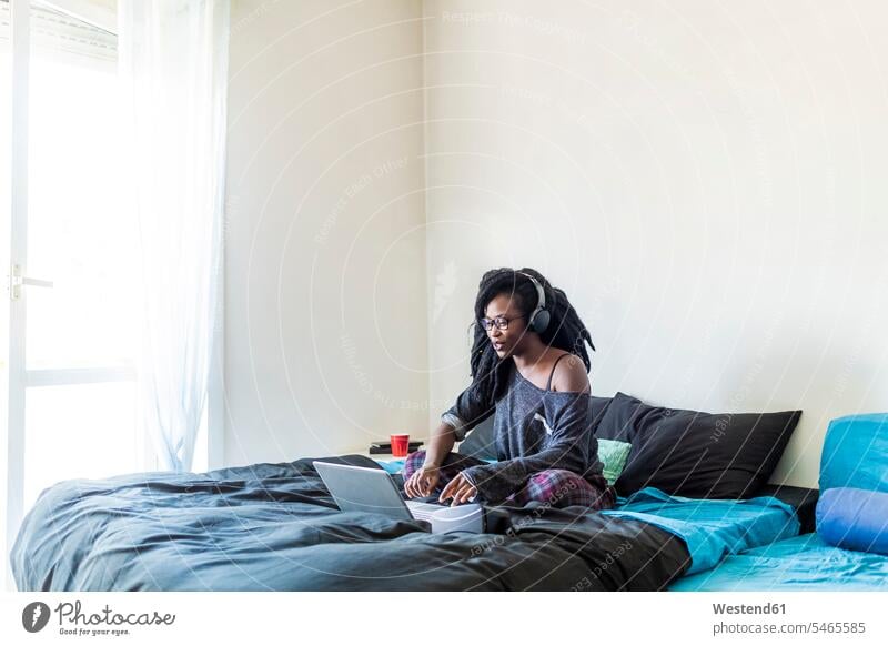 Young woman using laptop on bed at home Technological technologies The Internet human human being human beings humans person persons 1 one person only