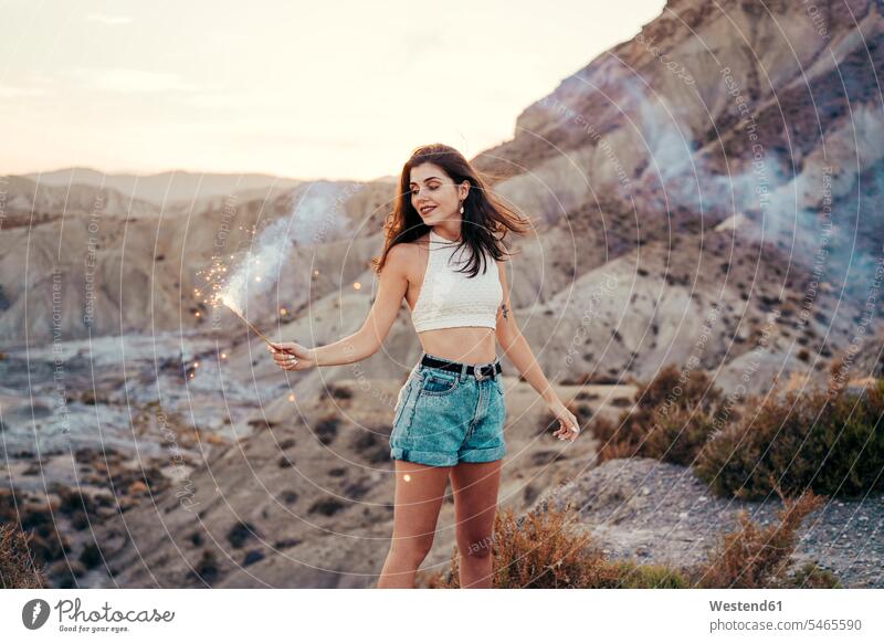 Portrait of smiling young woman with sparkler at sunset, Almeria, Spain relax relaxing smile in the evening Late Evening seasons summer time summertime summery