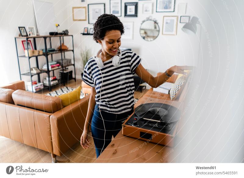 Young woman using record player at home human human being human beings humans person persons celibate celibates singles solitary people solitary person