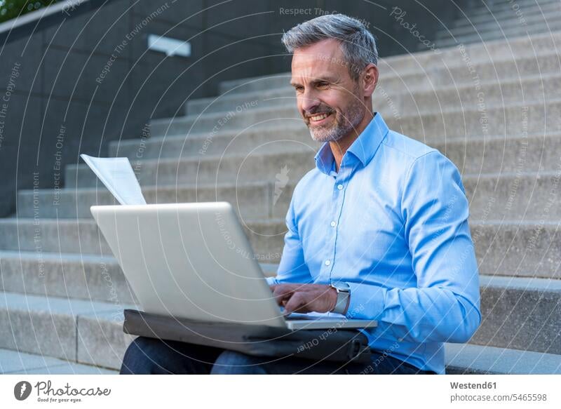 Portrait of businessman sitting on stairs using laptop use portrait portraits Laptop Computers laptops notebook Businessman Business man Businessmen
