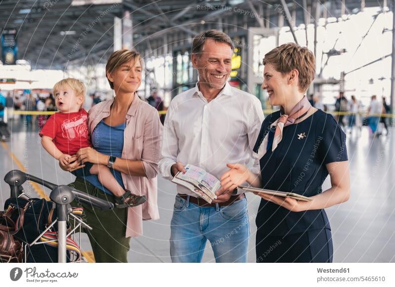 Happy family showing passports to airline employee at the airport employess baggage cart luggage cart baggage carts luggage carts terminal airports families