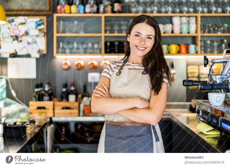 Happy female owner standing arms crossed in coffee shop color image colour image indoors indoor shot indoor shots interior interior view Interiors day