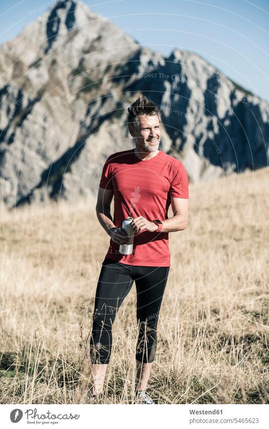 Austria, Tyrol, smiling athlete standing on alpine meadow Alpine Meadow Alpine Meadows mountain range mountains mountain ranges man men males Sportspeople