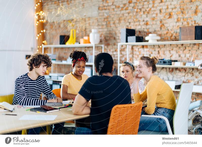 Young people sitting together at table and talking human human being human beings humans person persons caucasian appearance caucasian ethnicity european