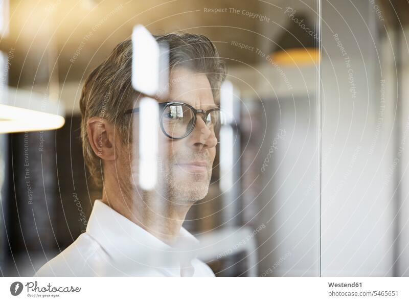 Mature businessman wearing glasses looking out of window windows Businessman Business man Businessmen Business men view seeing viewing specs Eye Glasses