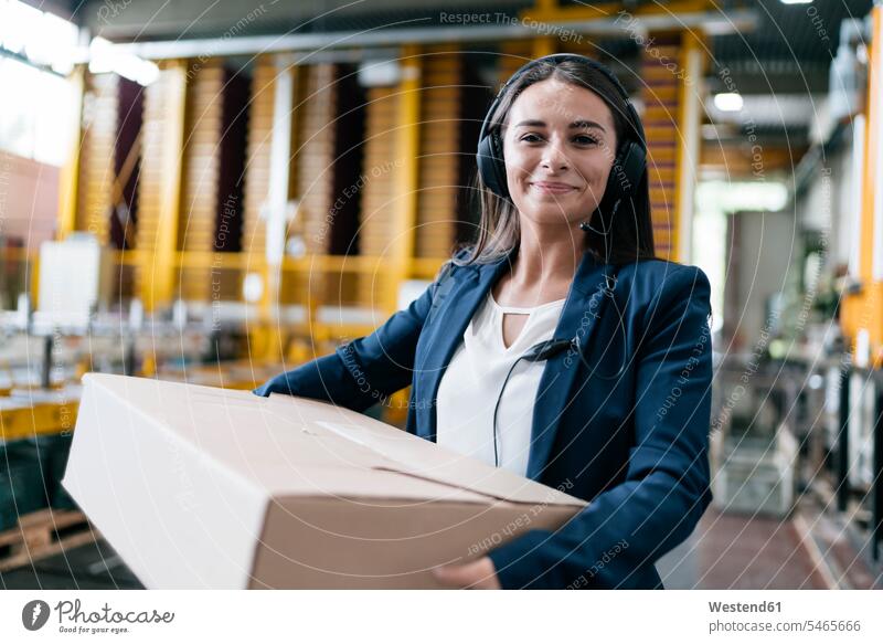 Young woman working at parcel service, carrying parcel in warehouse packet packets parcels employee employess messenger service courier service storage dumps
