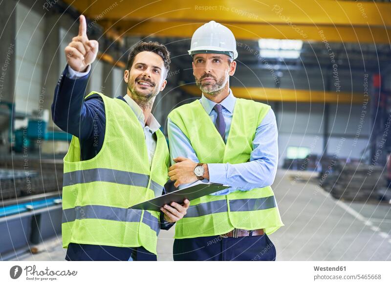 Two managers wearing protective workwear talking in factory Businessman Business man Businessmen Business men males Protective Workwear Protective Work Wear