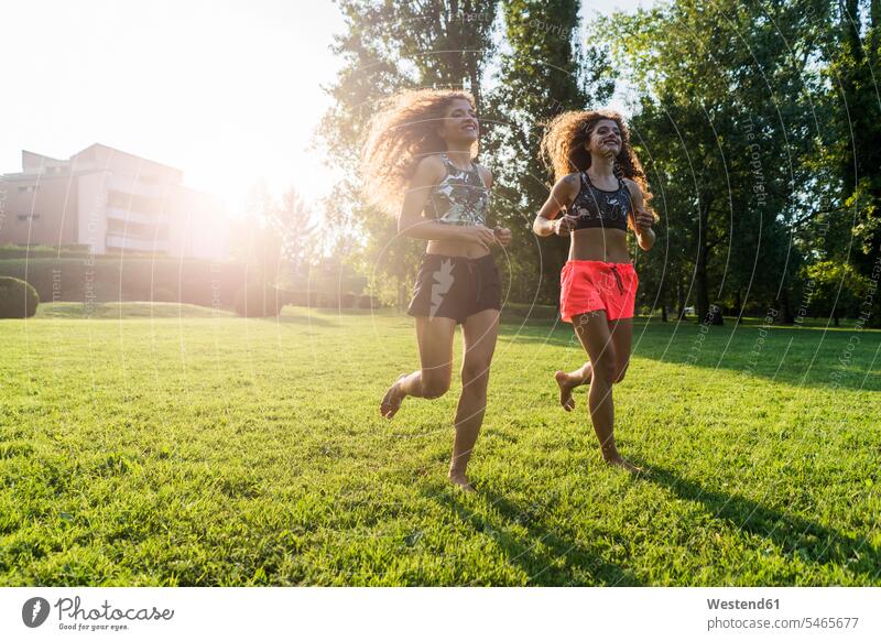 Twin sisters jogging barefoot on a meadow twin sister twin sisters Jogging naked feet naked foot Barefeet Bare Feet Bare Foot Barefooted bare-footed meadows